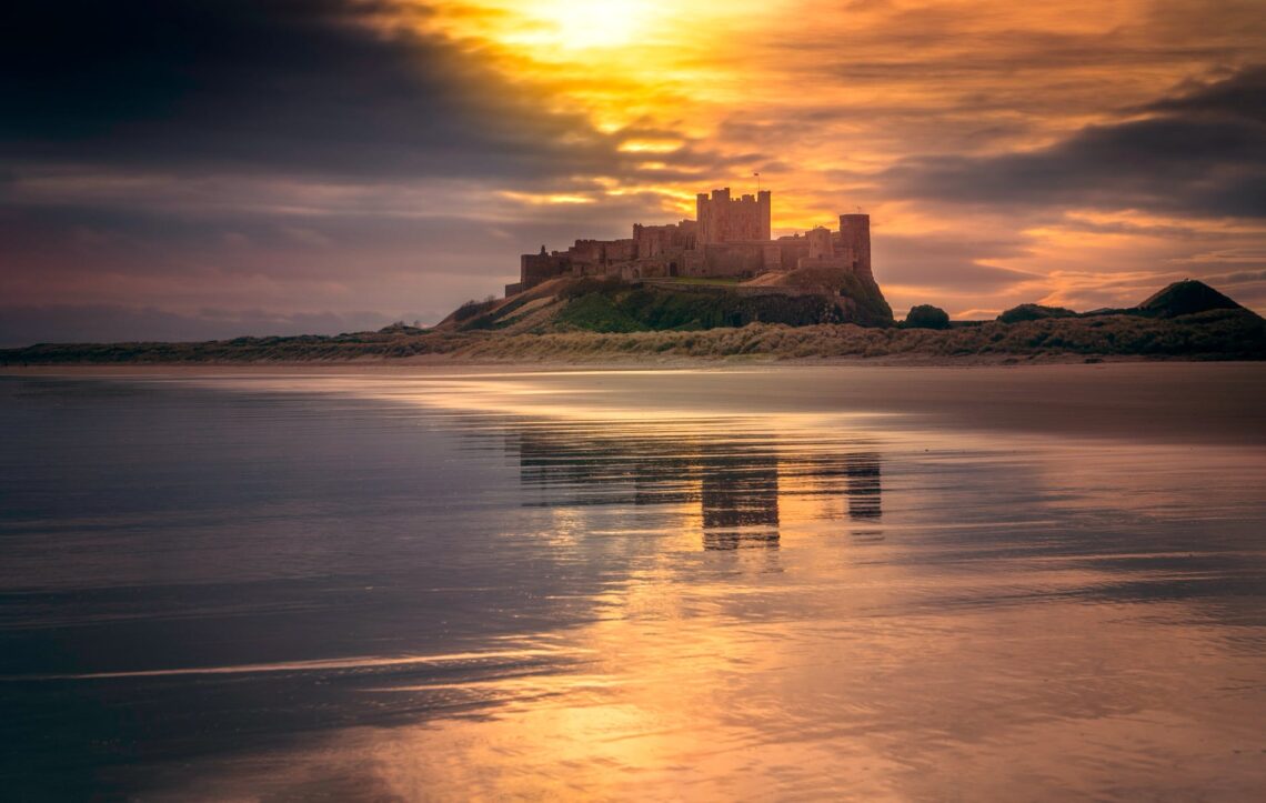 castle near body of water under golden hour